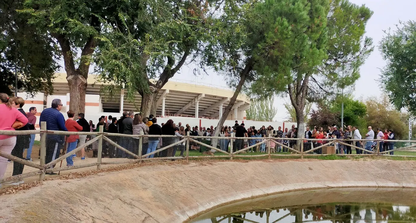 Grupo de personas junto a una laguna en un recinto al aire libre