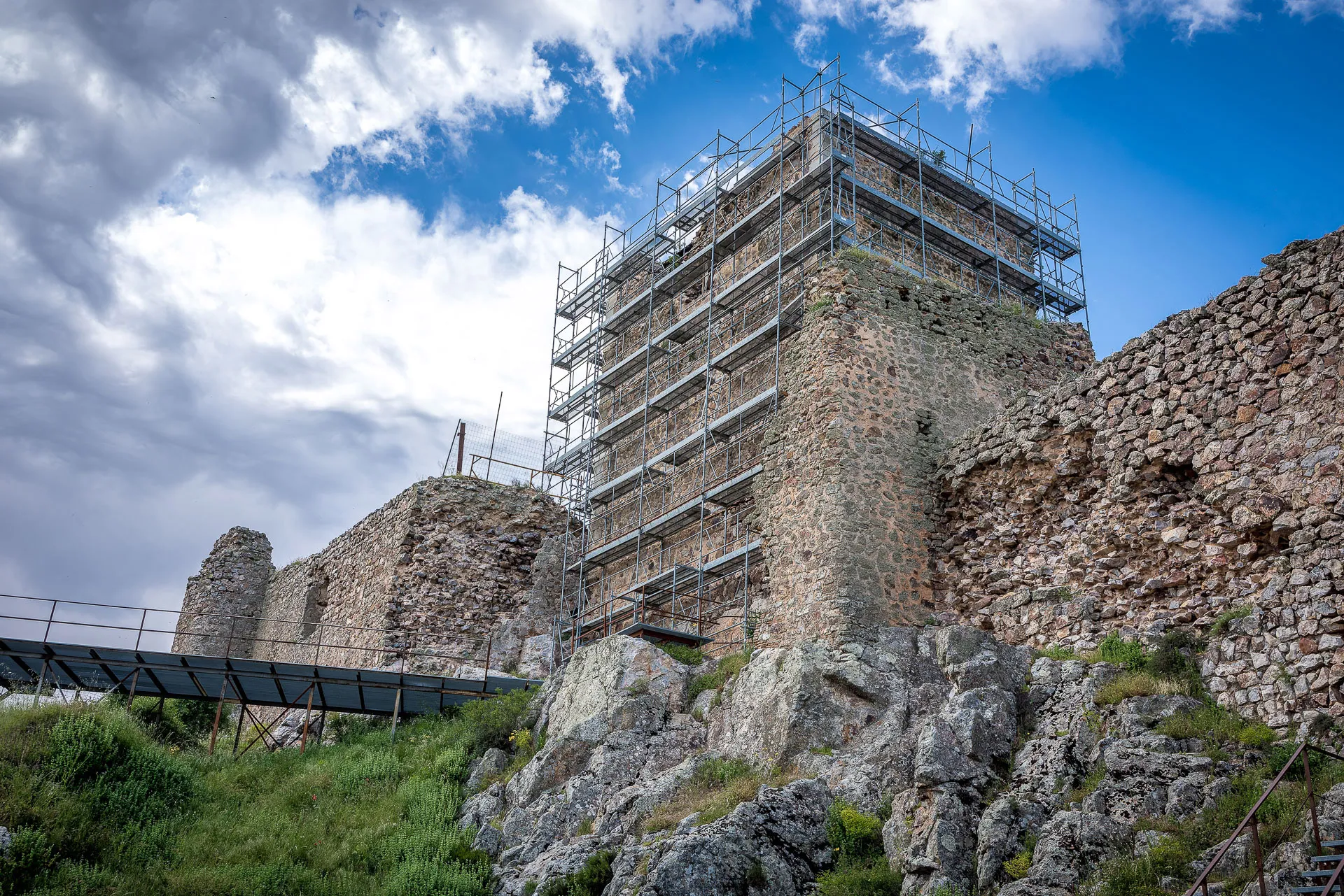 Torre en restauración entre muros de piedra
