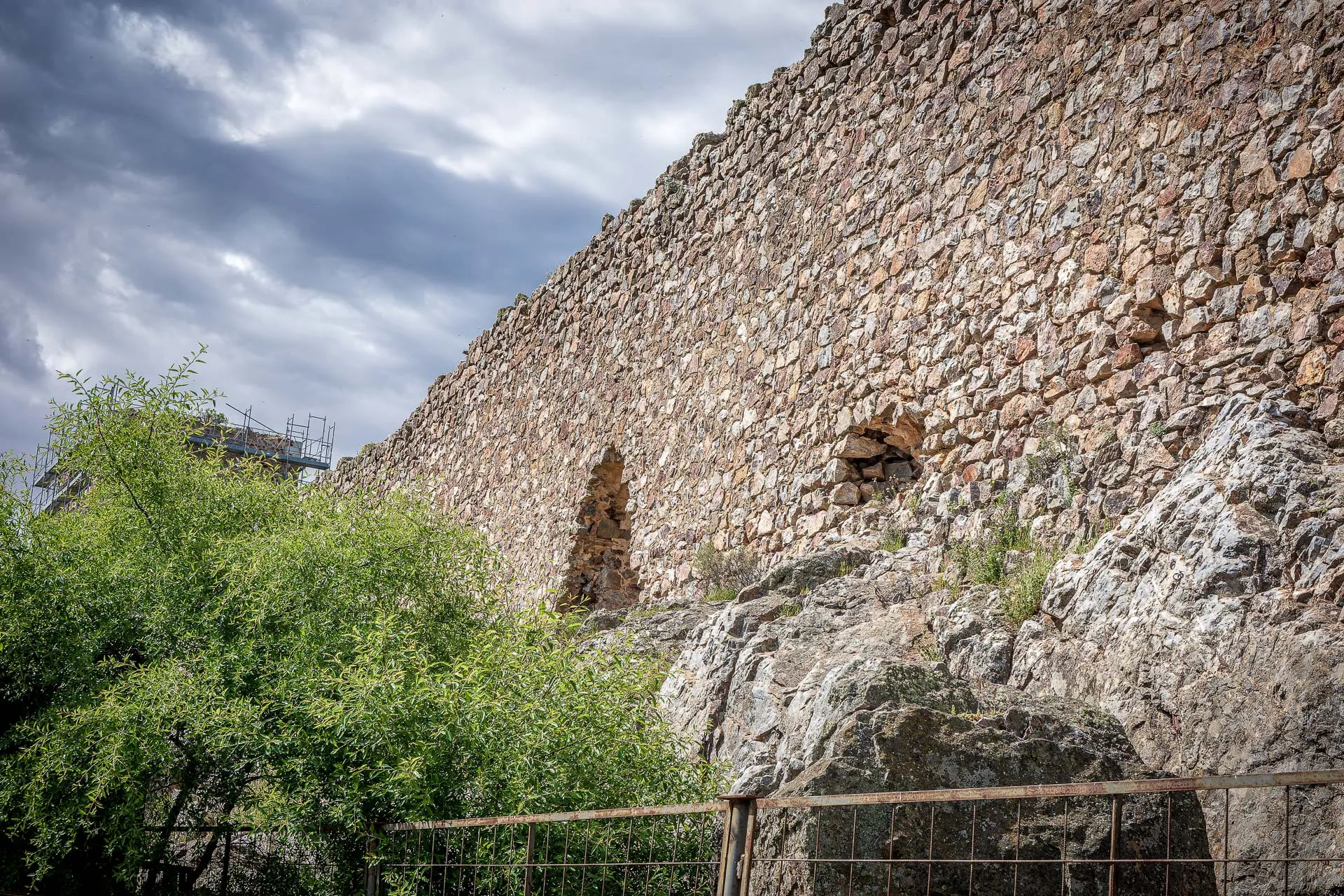 Muralla de piedra sobre rocas y vegetación