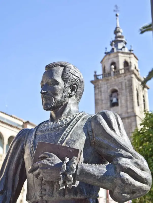 Estatua de escritor con campanario al fondo