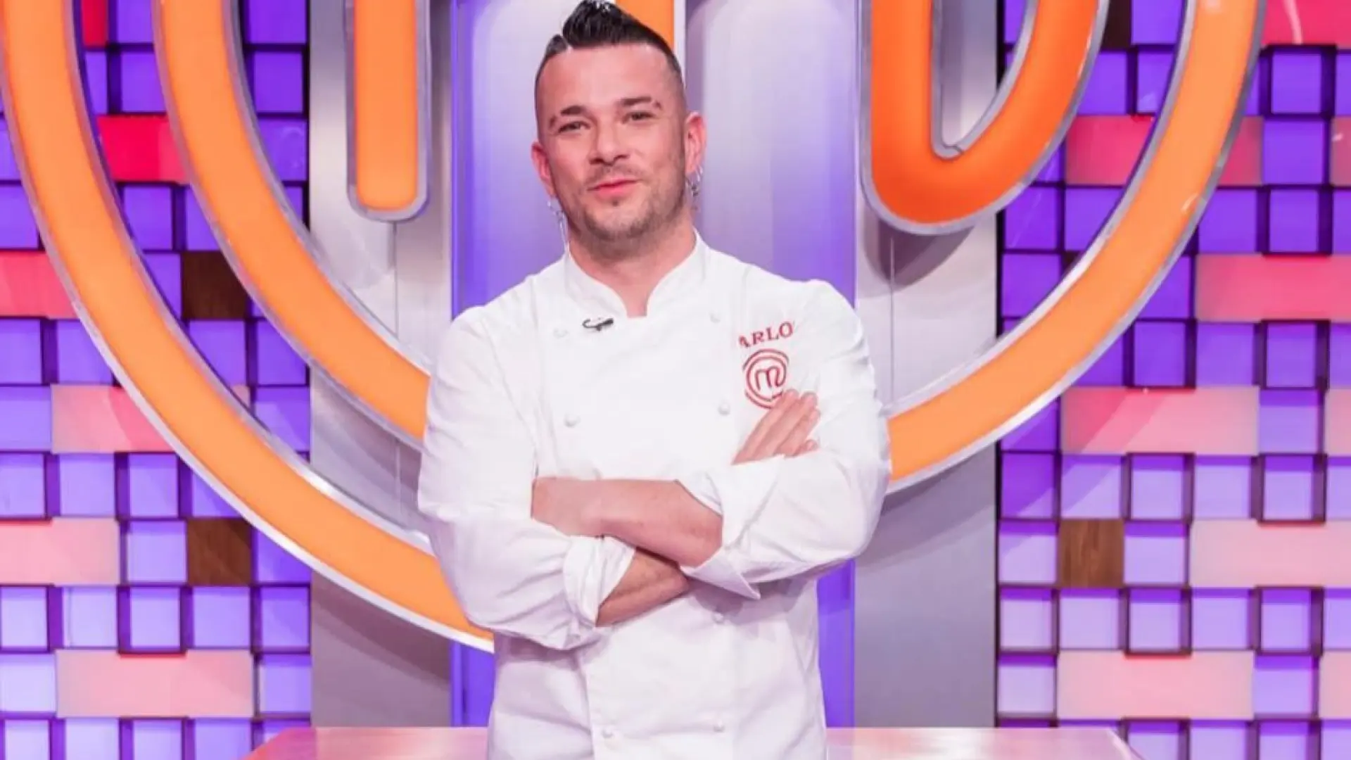 Cocinero con brazos cruzados frente a un plató de concurso culinario