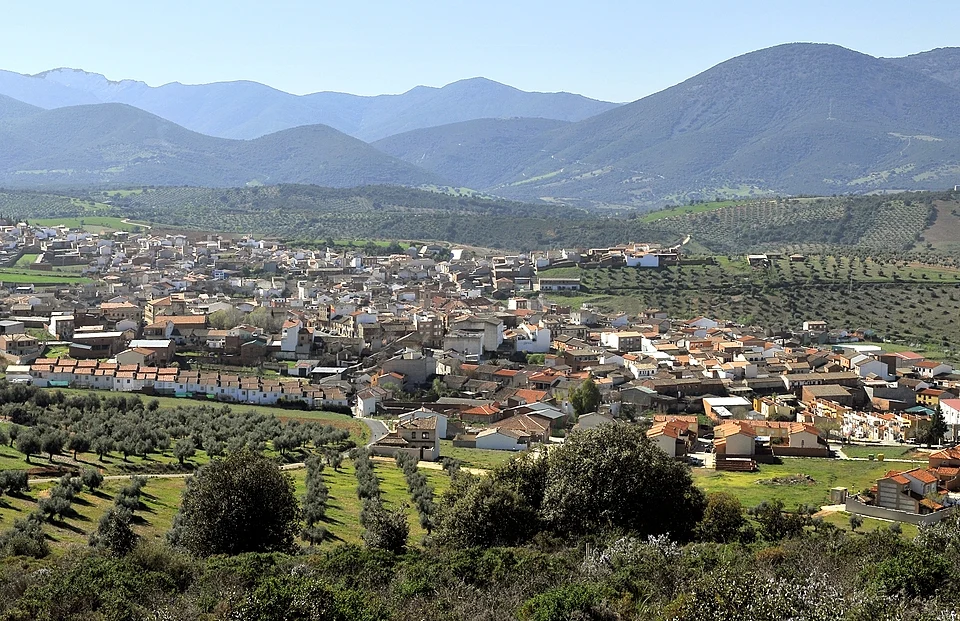 Vista panorámica de pueblo entre olivares y montañas