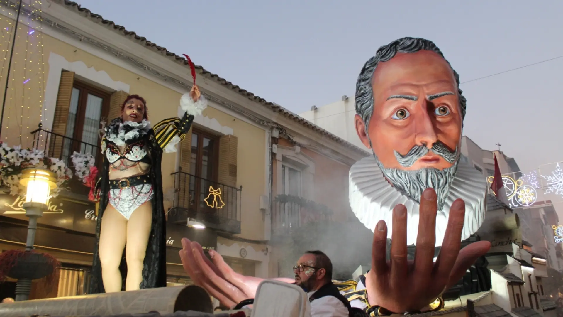 Figura gigante en desfile festivo con público alrededor